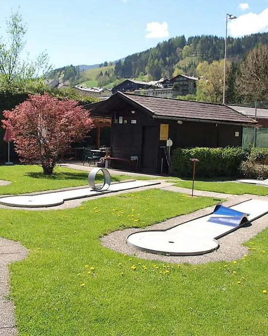 Minigolfplatz im Freien mit Hindernissen und grünem Rasen in Berglandschaft